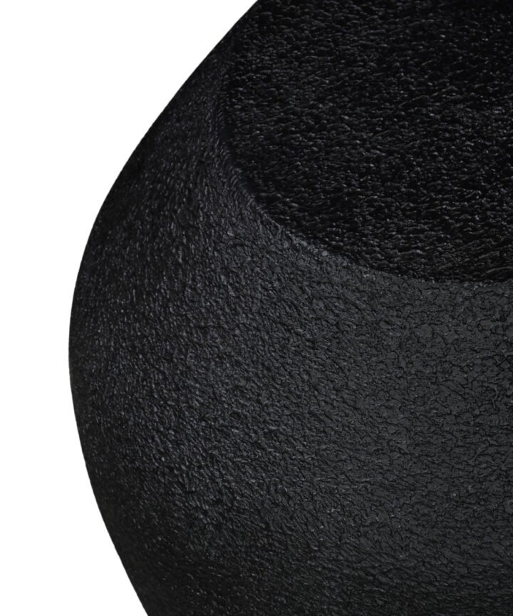 Close-up of a black textured surface from the Mia Modern Geometric Side Table by Red Frog Trading, highlighting the rugged finish and curved edge detail.